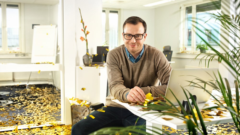 Mann bak PC på kontor, glitter på bakken